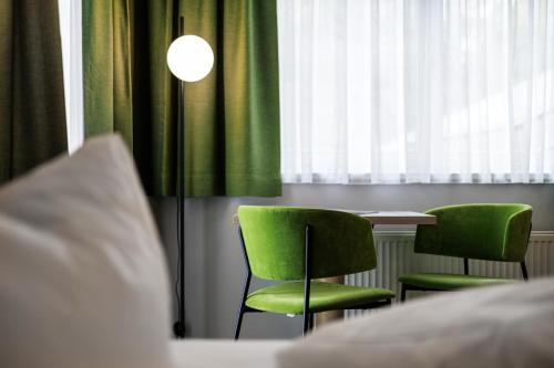 a room with a table and two green chairs at Alpenaussicht in Obergurgl