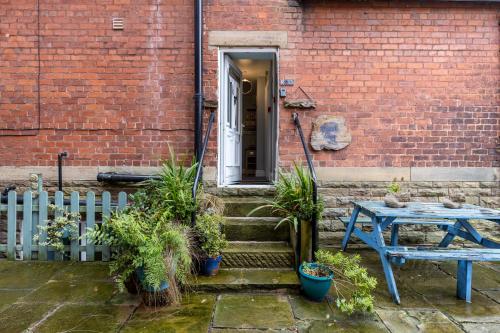 a patio with a table and a brick building at Beach Snug in Lytham St Annes