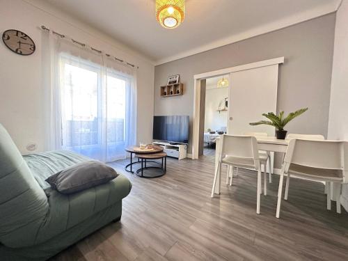a living room with a couch and a table and chairs at Paradis - Hyper Centre, a deux pas de la Mer ! in Canet-en-Roussillon