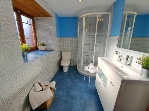 Baño azul con lavabo y aseo en La Escapada 