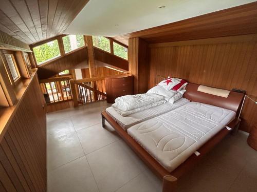 a large bed in a room with wooden walls at Idyllisches Einfamilienhaus bei München in Munich