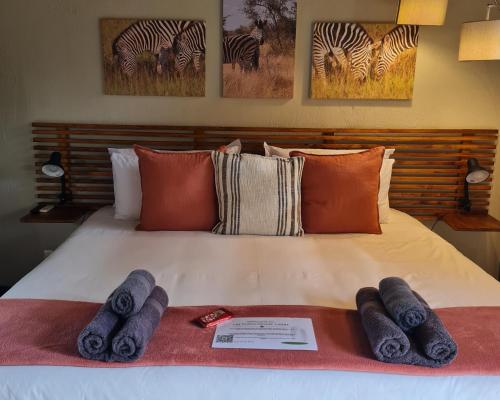 a bed with blue towels on top of it at The Dreamcatcher Lodge in Hoedspruit