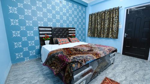 1 dormitorio con 1 cama con paredes azules y puerta negra en Shree Krishna Niwas, en Deoghar