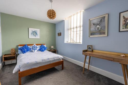 a bedroom with a bed with blue walls at Beach Snug in Lytham St Annes
