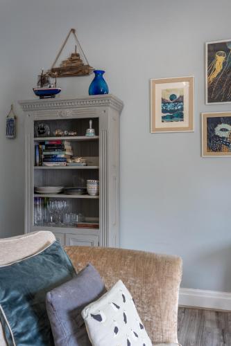 a living room with a couch and a book shelf at Beach Snug in Lytham St Annes