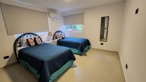 ein Schlafzimmer mit zwei Betten und einem Fenster in der Unterkunft Villa Lol-Ha in Cancún