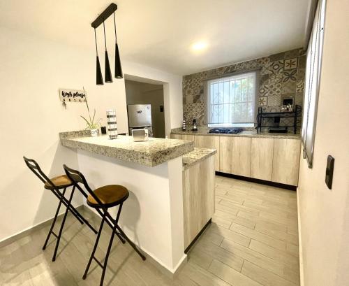 a kitchen with a counter and two stools in front of it at Villa Lol-Ha in Cancún