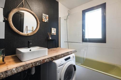 a bathroom with a sink and a washing machine at Appartement Uccelli - Cocoon just a stone's throw from the centre of Megève in Megève