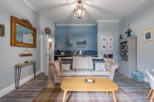 a living room with a couch and a table at Beach Snug in Lytham St Annes