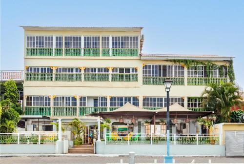un grand bâtiment jaune avec balcon et lumière de rue dans l'établissement Hotel Peten, à Flores