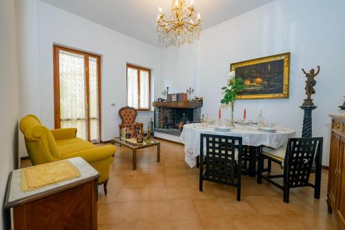 sala de estar con mesa y chimenea en Villino Liberty nel cuore della Marsica en Luco dei Marsi