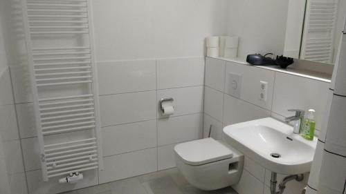 a white bathroom with a toilet and a sink at Sroom Metzingen in Metzingen
