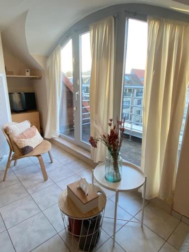 a living room with a vase of flowers on a table at Léonardo in Nieuwpoort