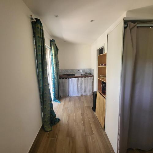 - un couloir dans une chambre dotée de parquet et de rideaux dans l'établissement La RoseDan, à Pianottoli-Caldarello
