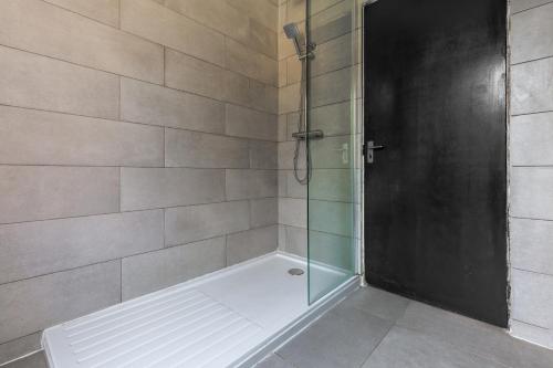 a bathroom with a shower with a glass door at Palatial Six Bedroom Haven in Northampton