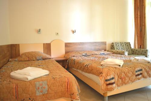 a hotel room with two beds with towels on them at Villas Ropotamo in Primorsko