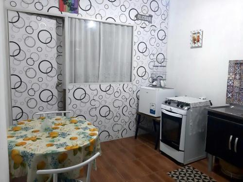 a kitchen with a stove and a table and a stove top oven at Loft aconchegante - Centro Niterói in Niterói