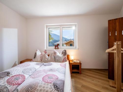 1 dormitorio con 1 cama grande y ventana en Haus SaRo, en Hopfgarten im Brixental