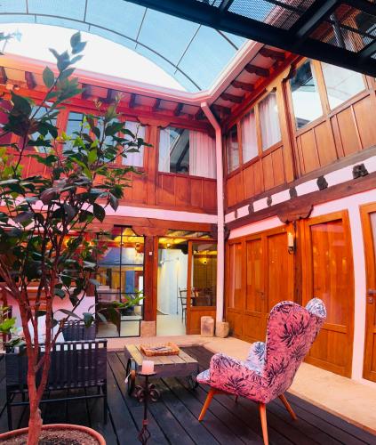 a patio with a chair and a table and a tree at Hotel Caney Villa de Leyva in Villa de Leyva