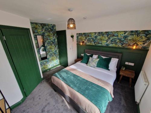 a bedroom with a large bed with green walls at The Coastal Hideaway in Bridlington