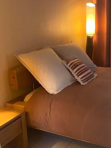 ein Bett mit einem weißen Kissen darüber in der Unterkunft JOLI GÎTE ARDÈCHOIS in Plats