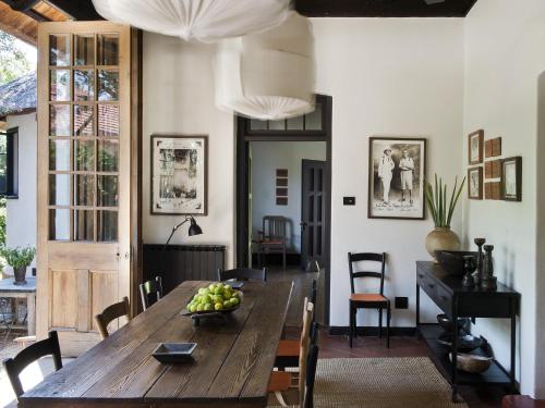 comedor con mesa de madera y sillas en Satyagraha House en Johannesburgo