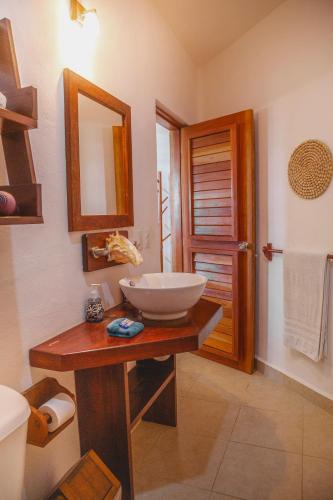 a bathroom with a sink and a mirror at Casa Colibrí Tankah in Tulum