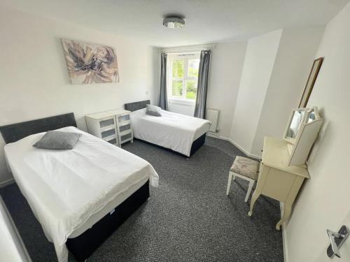 a hotel room with two beds and a window at Stylish apartment in city centre in Oxford