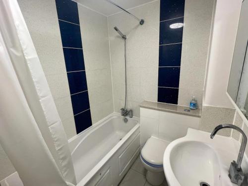 ein Badezimmer mit einer weißen Badewanne, einem WC und einem Waschbecken in der Unterkunft Stylish apartment in city centre in Oxford