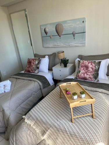 a room with two beds and a coffee table at Travellar Spot 1225A in Ribeirão Preto