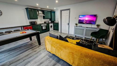 a living room with a couch and a kitchen at Modern City Centre Apartment in Belfast