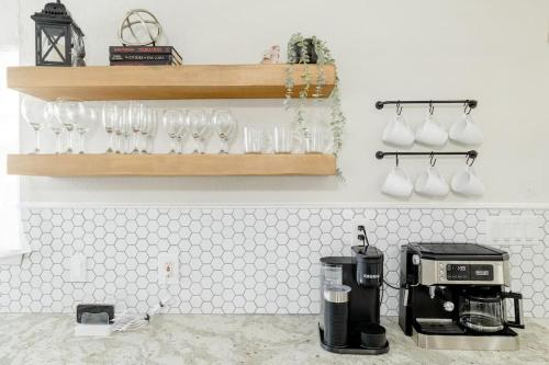 a kitchen counter with a coffee maker and glasses on a shelf at 2 bed 2 bath Modern Farmhouse in Old Town Spring in Spring
