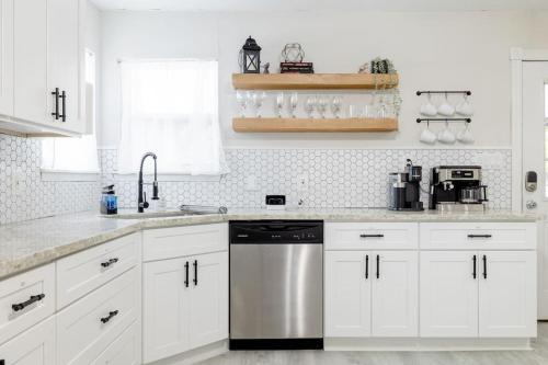 a kitchen with white cabinets and a stainless steel dishwasher at 2 bed 2 bath Modern Farmhouse in Old Town Spring in Spring