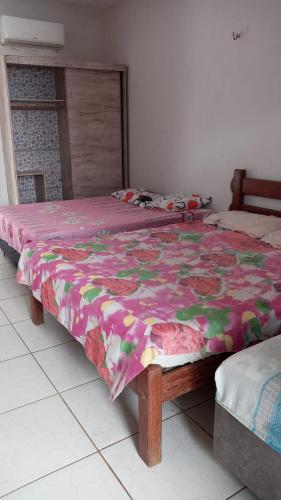 um quarto com 2 camas e um edredão florido em Pousada leblon em Caucaia