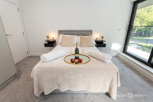 a bedroom with a bed with a table on it at Carbery Ridge by Grandeur Property in Bournemouth
