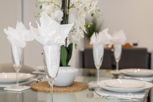 a table with three wine glasses with white flowers at Carbery Ridge by Grandeur Property in Bournemouth