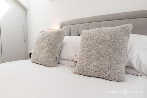 a white bed with two pillows on it at Carbery Ridge by Grandeur Property in Bournemouth