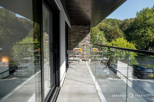 a balcony with a table and chairs looking out the window at STUNNING Townhouse, Sleeps 8, Garden & Parking - Carbery Ridge in Bournemouth