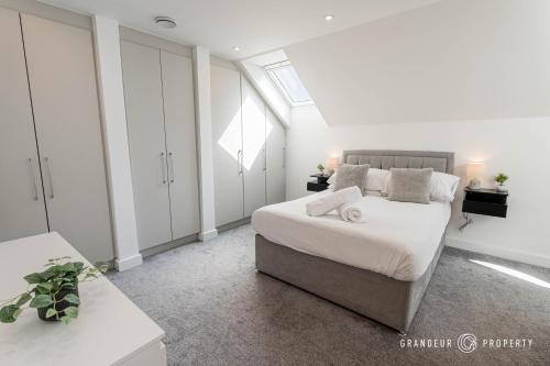a white bedroom with a bed and a window at Carbery Ridge by Grandeur Property in Bournemouth