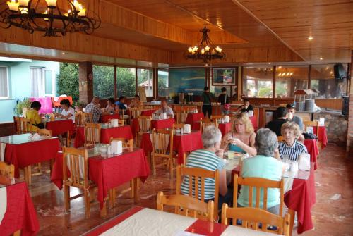 a group of people sitting at tables in a restaurant at Turk Hotel in Oludeniz