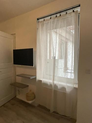 Cette chambre dispose d'une fenêtre avec un rideau blanc. dans l'établissement Studio cosy quartier observatoire, à Strasbourg