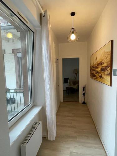 a hallway with a large window and a living room at Studio cosy quartier observatoire in Strasbourg