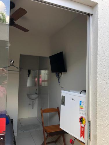 uma pequena cozinha com um frigorífico e uma televisão em Suítes Saraiva em Uberlândia