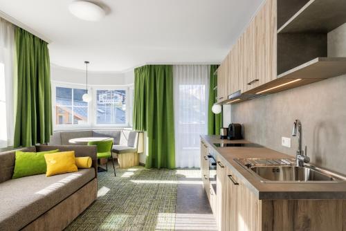 a living room with a couch and a kitchen at Alpenaussicht in Obergurgl