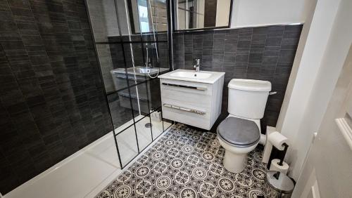 a bathroom with a toilet and a sink and a shower at Modern City Centre Apartment in Belfast