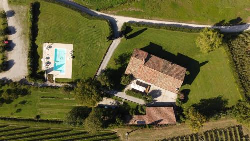 Elle offre une vue sur une maison et une cour avec une piscine. dans l'établissement Fenil Conter Cottage & Suite, à Pozzolengo