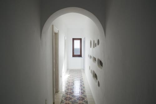 a hallway with an archway in a white room at Boutique Hotel I Cinque Balconi in Santa Marina Salina