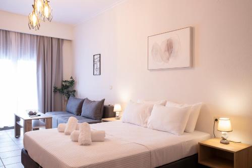 a bedroom with a large white bed and a couch at Olymp-rooms in Litochoro