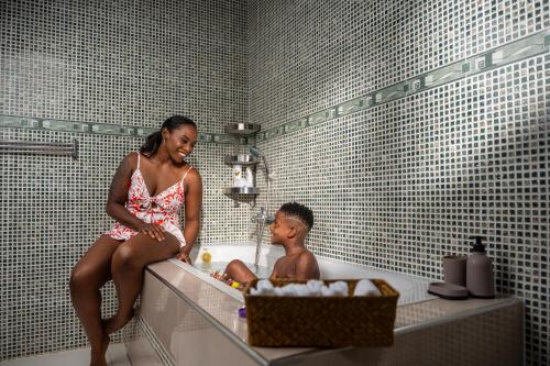 a woman and a boy sitting in a bath tub at D.D. Amazonica Bungalows in Landsboerderij