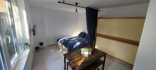 une petite pièce avec un lit et une table dans l'établissement logement avec terrasse, à Saint-Julien-lʼArs